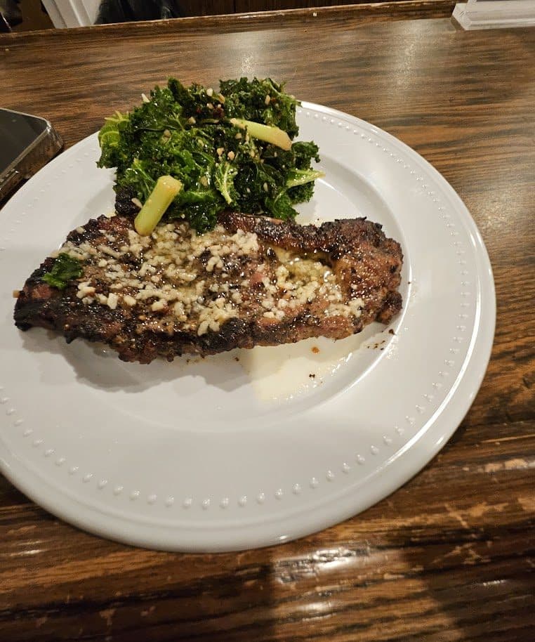 Seared steak plated with broccoli and greens